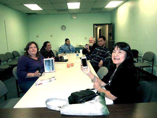 the apple devices club meeting with everyone holding up their apple devices.